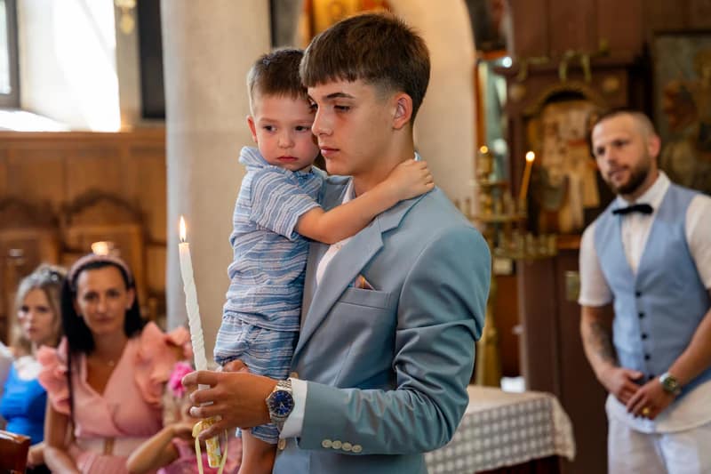 дете и кръстник по време на кръщене в църква
